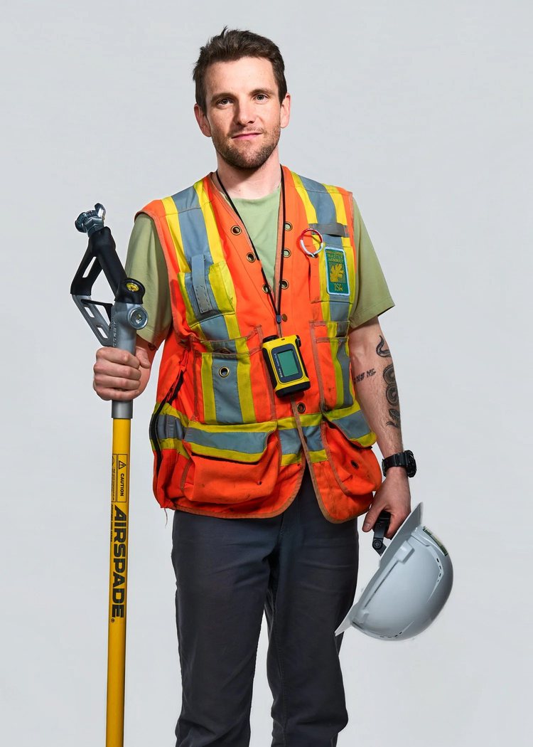 Brent Hocking in a high-visibility vest, holding an AirSpade and a hard hat